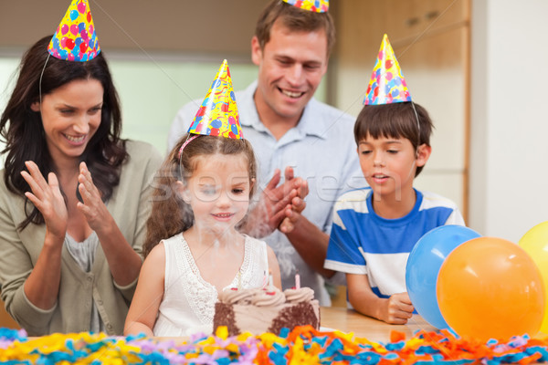 Parents applauding her little daughter who just blew out the candles on birthday cake Stock photo © wavebreak_media
