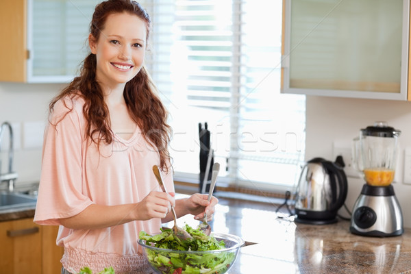 Smiling woman stirring salad Stock photo © wavebreak_media