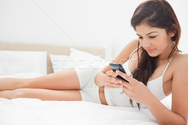 женщину нижний кровать смартфон рук улыбка Сток-фото © wavebreak_media