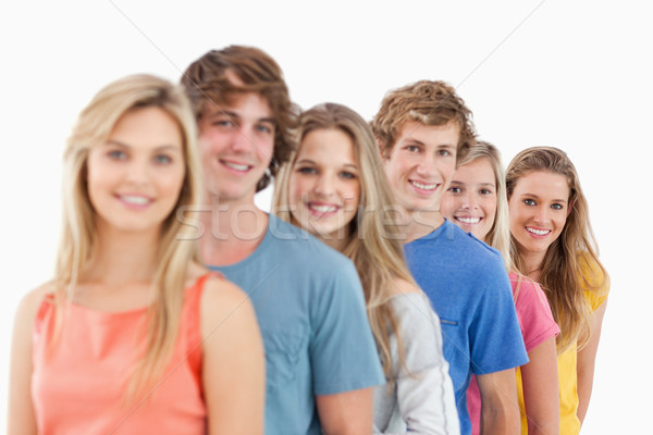 A smiling group standing behind each other at an angle while looking at the camera Stock photo © wavebreak_media