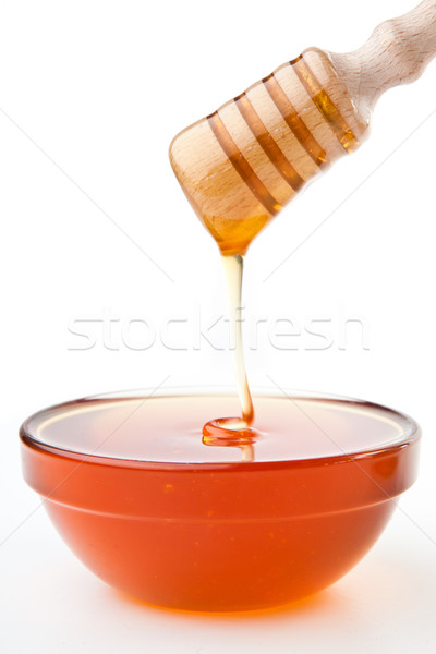 Honey sticky trickle dropping in bowl against a white background Stock photo © wavebreak_media