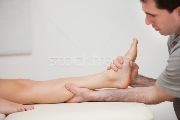 Serious physiotherapist holding the foot of a patient indoors Stock photo © wavebreak_media