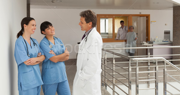 Three doctors standing in the hallway of a hospital while discoursing Stock photo © wavebreak_media