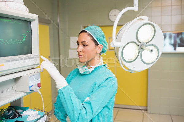 Femeie chirurg în picioare monitoriza chirurgie cameră Imagine de stoc © wavebreak_media