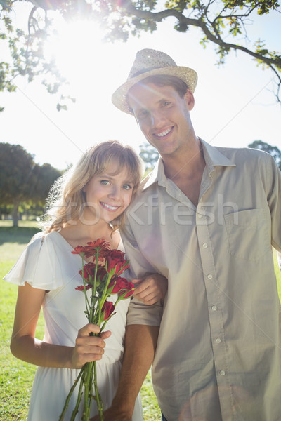 Attractive blonde holding roses standing with partner smiling at Stock photo © wavebreak_media