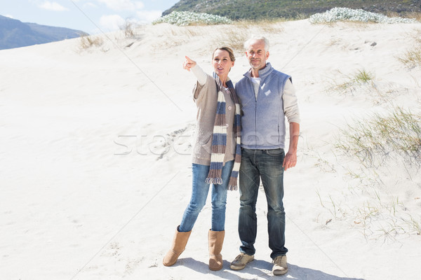 Stock photo: Attractive couple standing holding hands on the beach