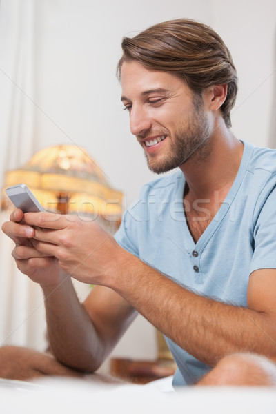 Jóképű férfi ül ágy sms chat telefon otthon Stock fotó © wavebreak_media