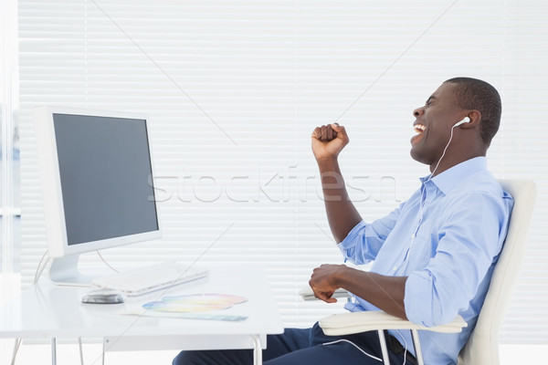 Businessman listening to music while he works Stock photo © wavebreak_media