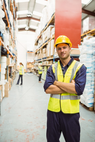 Warehouse worker smiling at camera with arms crossed Stock photo © wavebreak_media