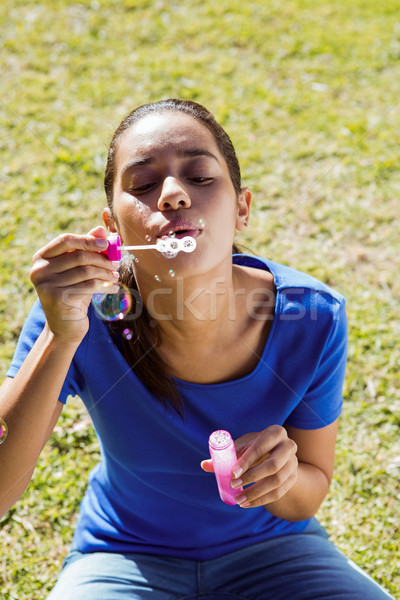 Pretty woman blowing bubbles in the park Stock photo © wavebreak_media