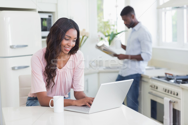 Mulher bonita usando laptop contrariar casa cozinha computador Foto stock © wavebreak_media