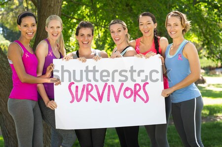 Bootcamp against fitness group holding poster in park Stock photo © wavebreak_media