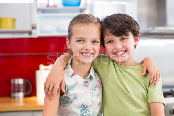 Siblings standing with arm around in kitchen Stock photo © wavebreak_media