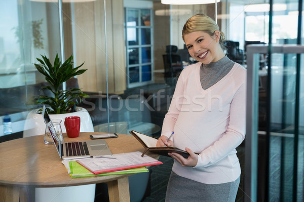 孕 女實業家 寫作 組織者 辦公室 肖像 商業照片 © wavebreak_media