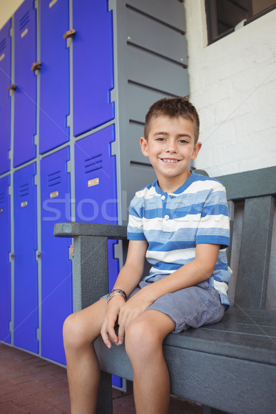 Portret uśmiechnięty chłopca posiedzenia ławce korytarz Zdjęcia stock © wavebreak_media