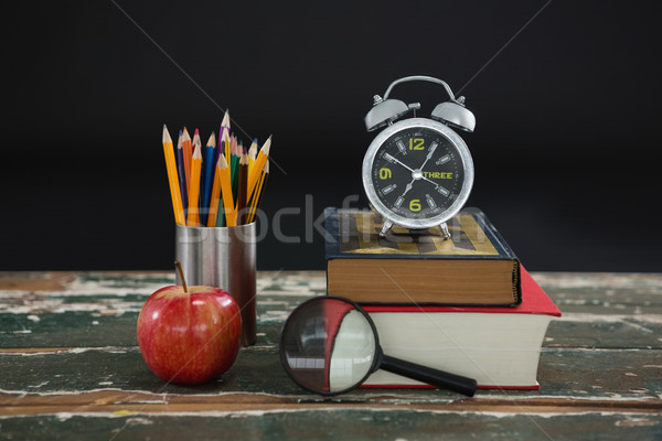[[stock_photo]]: Réveil · livres · stylo · pomme · loupe
