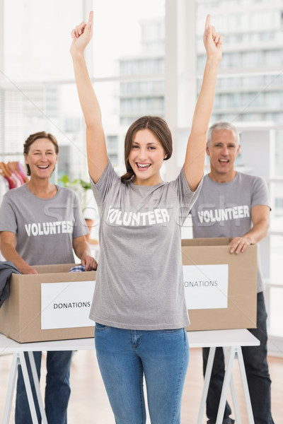 Cheering female volunteer in front of colleagues Stock photo © wavebreak_media