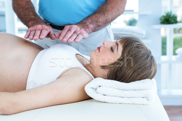 Therapist performing reiki over pregnant woman Stock photo © wavebreak_media