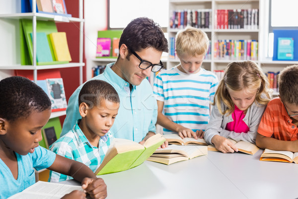 Maestro ninos lectura libro biblioteca escuela Foto stock © wavebreak_media