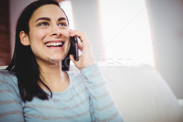 Femeie zambitoare vorbesc telefon zâmbitor acasă Imagine de stoc © wavebreak_media