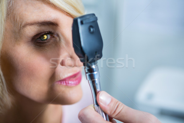 Optometrist examining female patient through ophthalmoscope Stock photo © wavebreak_media