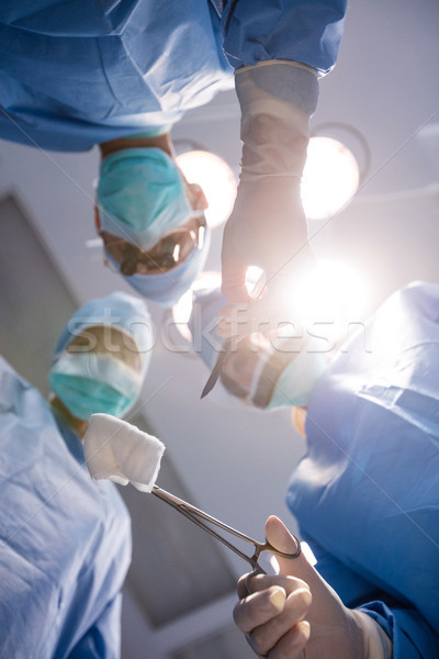 Stock photo: Surgeons holding surgical clamp with cotton swab in operation ro