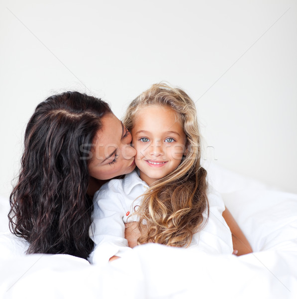 Cariñoso madre besar hija cama familia Foto stock © wavebreak_media