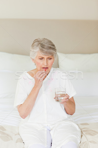 Sick senior woman taking her pills at home Stock photo © wavebreak_media
