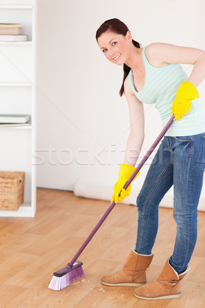 Good looking red-haired woman sweeping the floor at home Stock photo © wavebreak_media