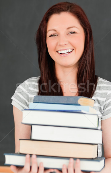 Laughing young woman bringing books in a classroom Stock photo © wavebreak_media
