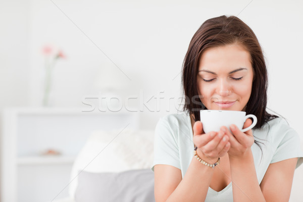 Delighted dark-haired woman drinking tea against a white background Stock photo © wavebreak_media