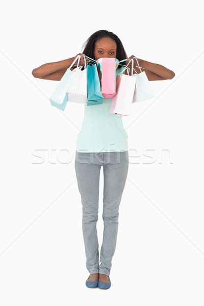 Young woman hiding behind her shopping on white background Stock photo © wavebreak_media