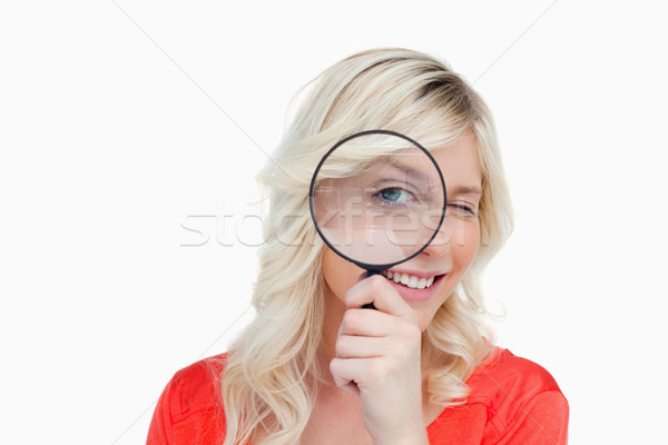 Woman looking through a magnifying glass while showing a blink of an eye Stock photo © wavebreak_media