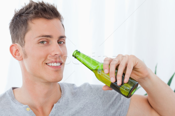 Sorridente homem cerveja mão beber garrafa Foto stock © wavebreak_media