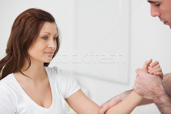 Woman sitting while a man examine her arm in a room Stock photo © wavebreak_media
