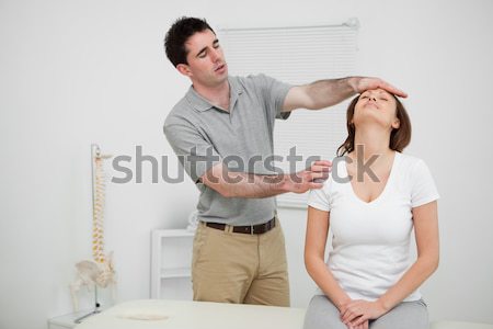 Practitioner looking at the neck of a patient in a medical room Stock photo © wavebreak_media