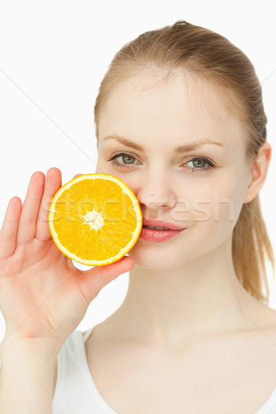 Woman placing an orange on her lips against white backgroun Stock photo © wavebreak_media