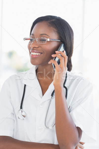 Stock photo: Smiling female doctor using mobile phone