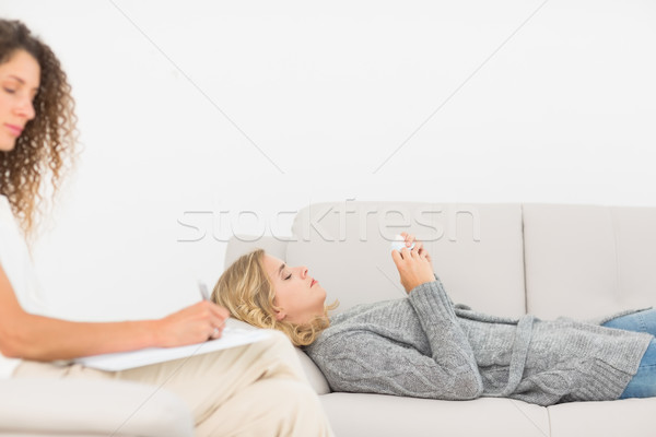 Stock photo: Therapist taking notes on her patient on the couch