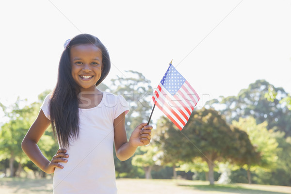 Little girl smiling at camera waving american flag Stock photo © wavebreak_media