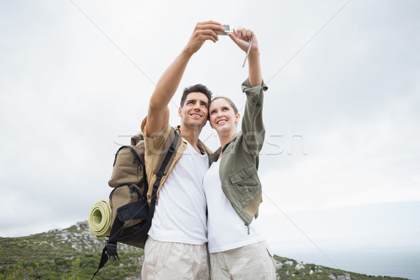 Hiking couple taking picture of themselves on mountain terrain Stock photo © wavebreak_media