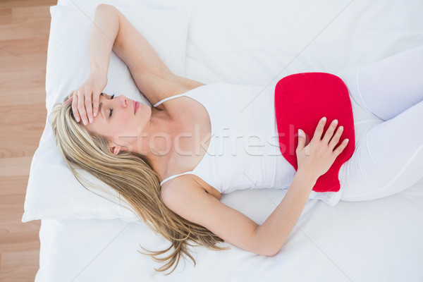 Woman using hot water bottle for her stomach pain Stock photo © wavebreak_media