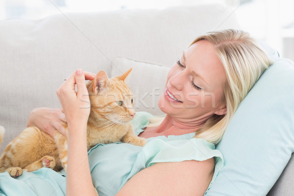 Woman stroking cat while lying on sofa Stock photo © wavebreak_media