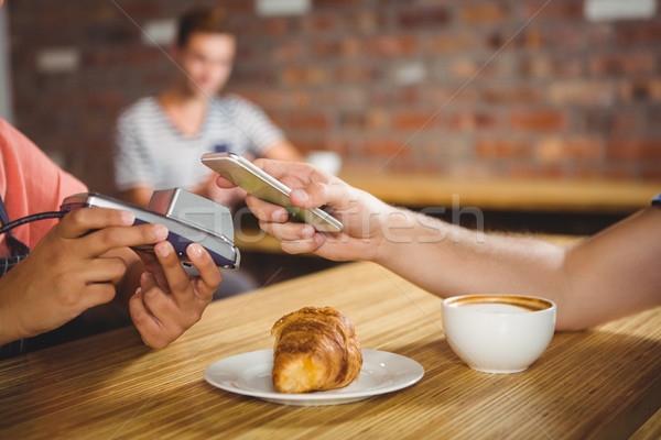 Paying for a croissant and a coffee with his smartphone Stock photo © wavebreak_media
