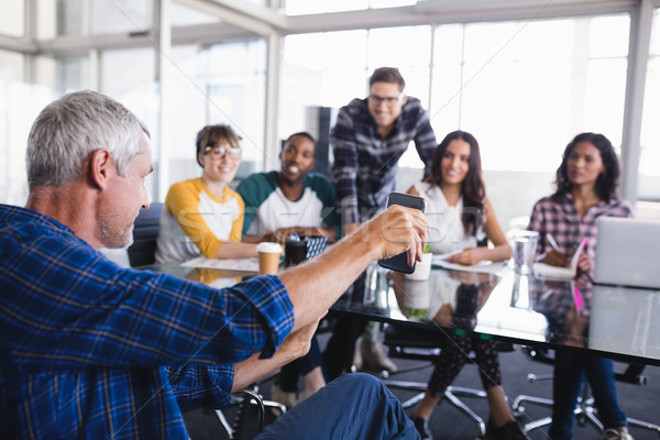 Stockfoto: Zakenman · tonen · mobiele · telefoon · team · werken · creatieve