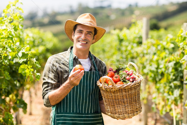 Portrait of happy farmer holding a basket of vegetables Stock photo © wavebreak_media