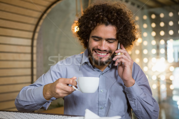 Man talking on mobile phone while having cup of tea Stock photo © wavebreak_media