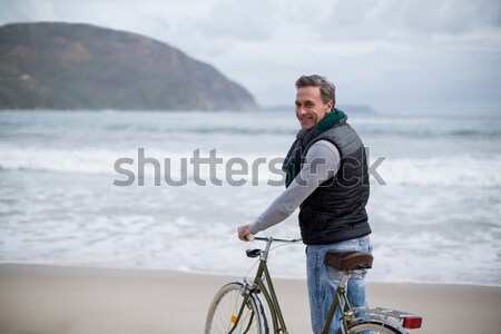 Uomo piedi bicicletta spiaggia felice Foto d'archivio © wavebreak_media