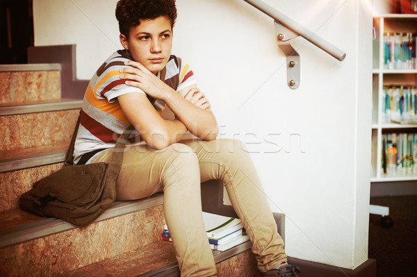 Sad schoolboy sitting alone on staircase in school Stock photo © wavebreak_media