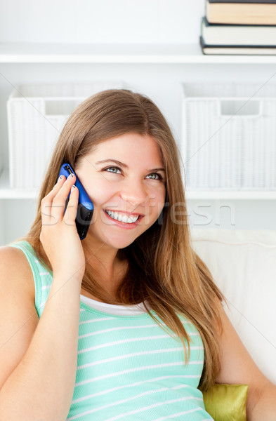 Glowing woman talking on phone sitting on a sofa at home Stock photo © wavebreak_media